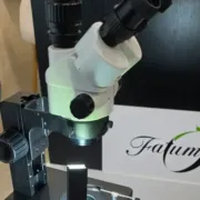 Optika OPTIGEM-20 gemmológiai sztereomikroszkóp a Fatumjewels vizsgálóasztalán, háttérben a Fatumjewels logó